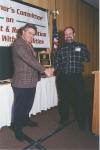 Denny Macom (plaid shirt), presents Tom Rentz with chairperson award at last year's event.
